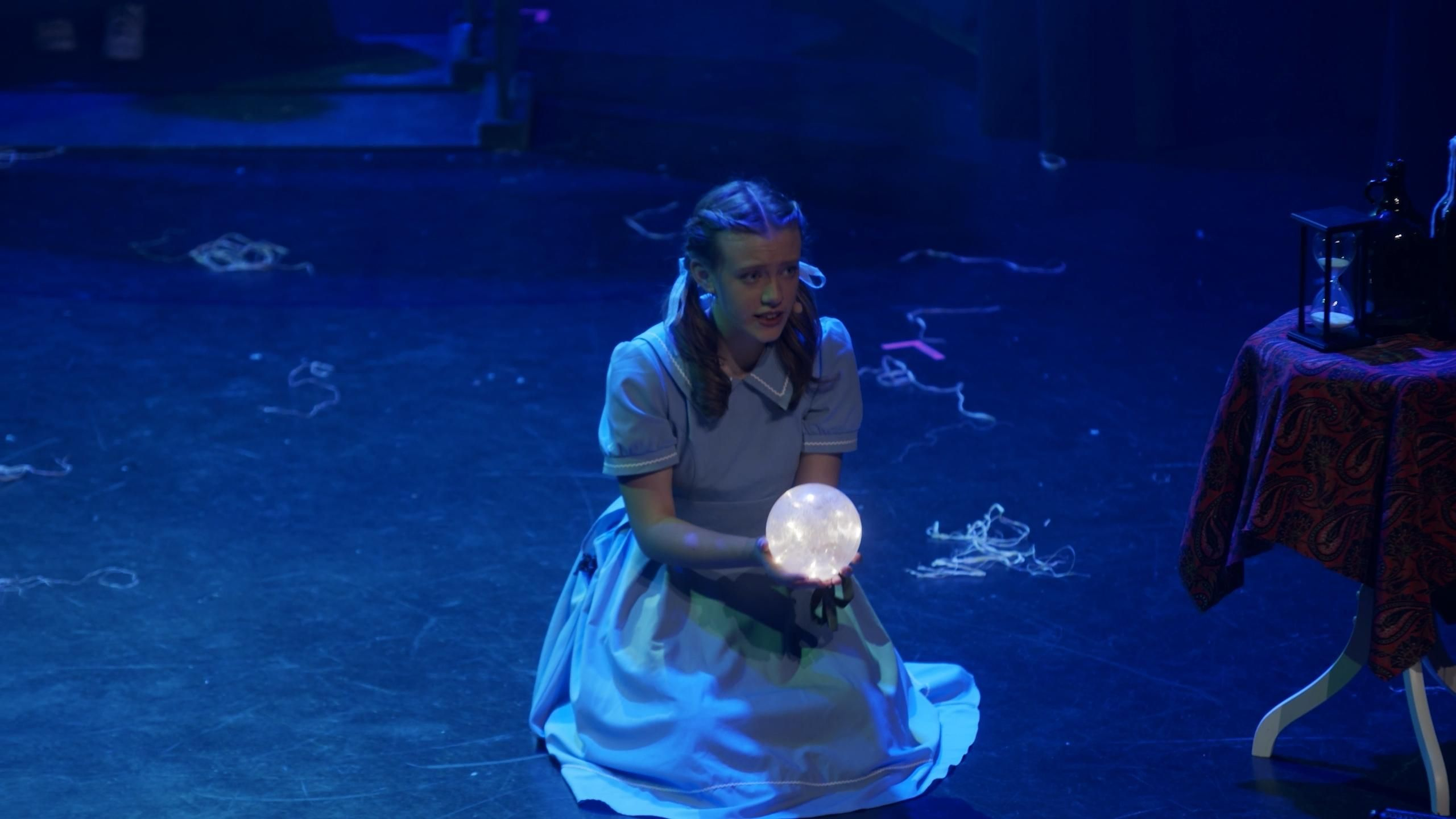 Dorothy sitter på gulv med lyskule i hendene