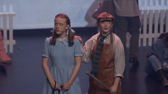 Dorothy og person i hatt på scenen